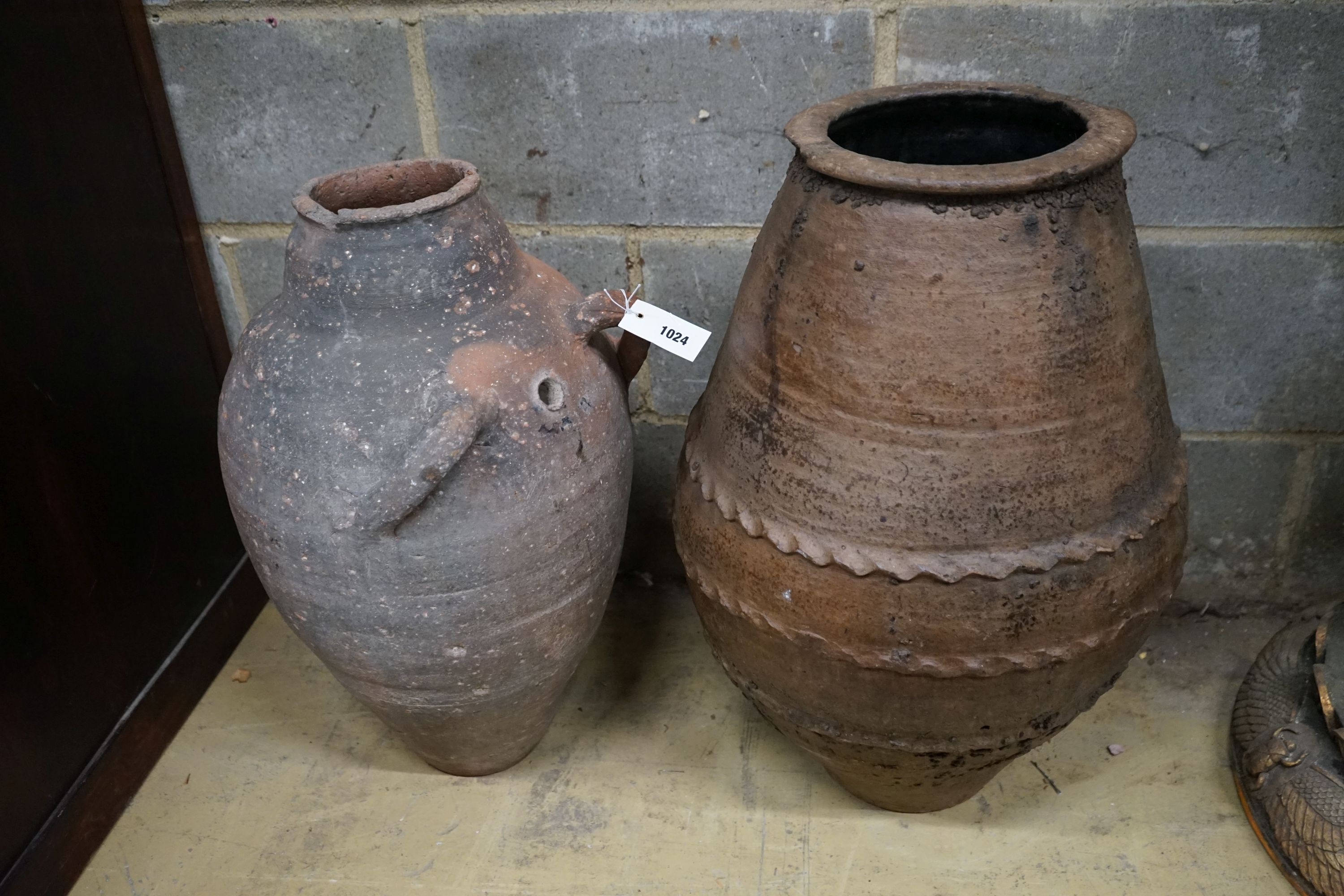 Two Greek style earthenware oil jars, largest height 67cm